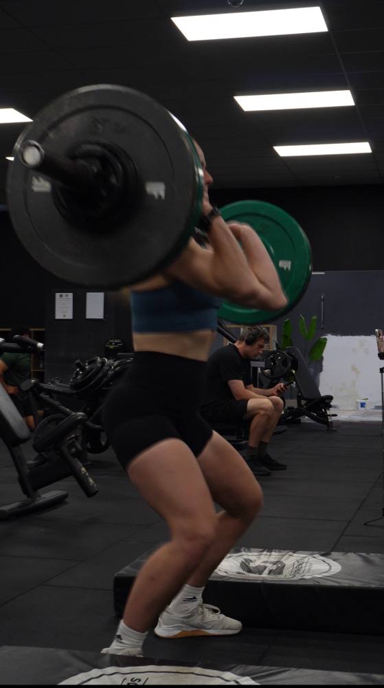 Member back-squatting on the Ultra Fitness strength floor