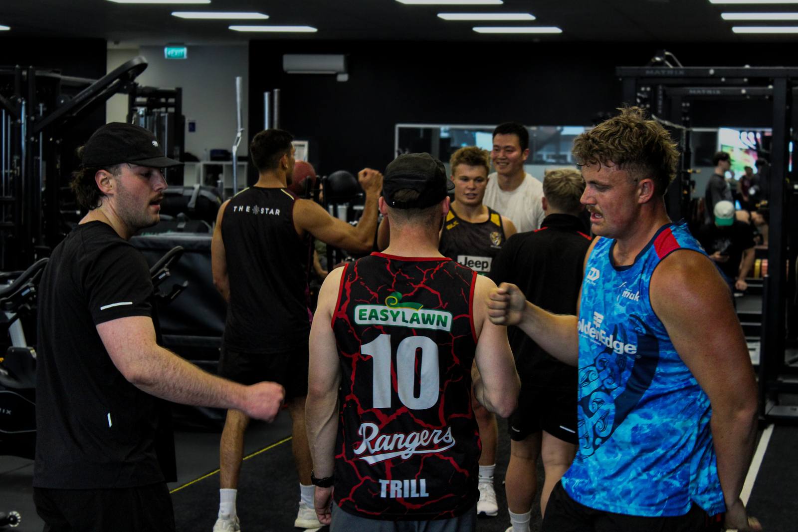 Rugby players and coaches fist-bumping between sets at Ultra Fitness