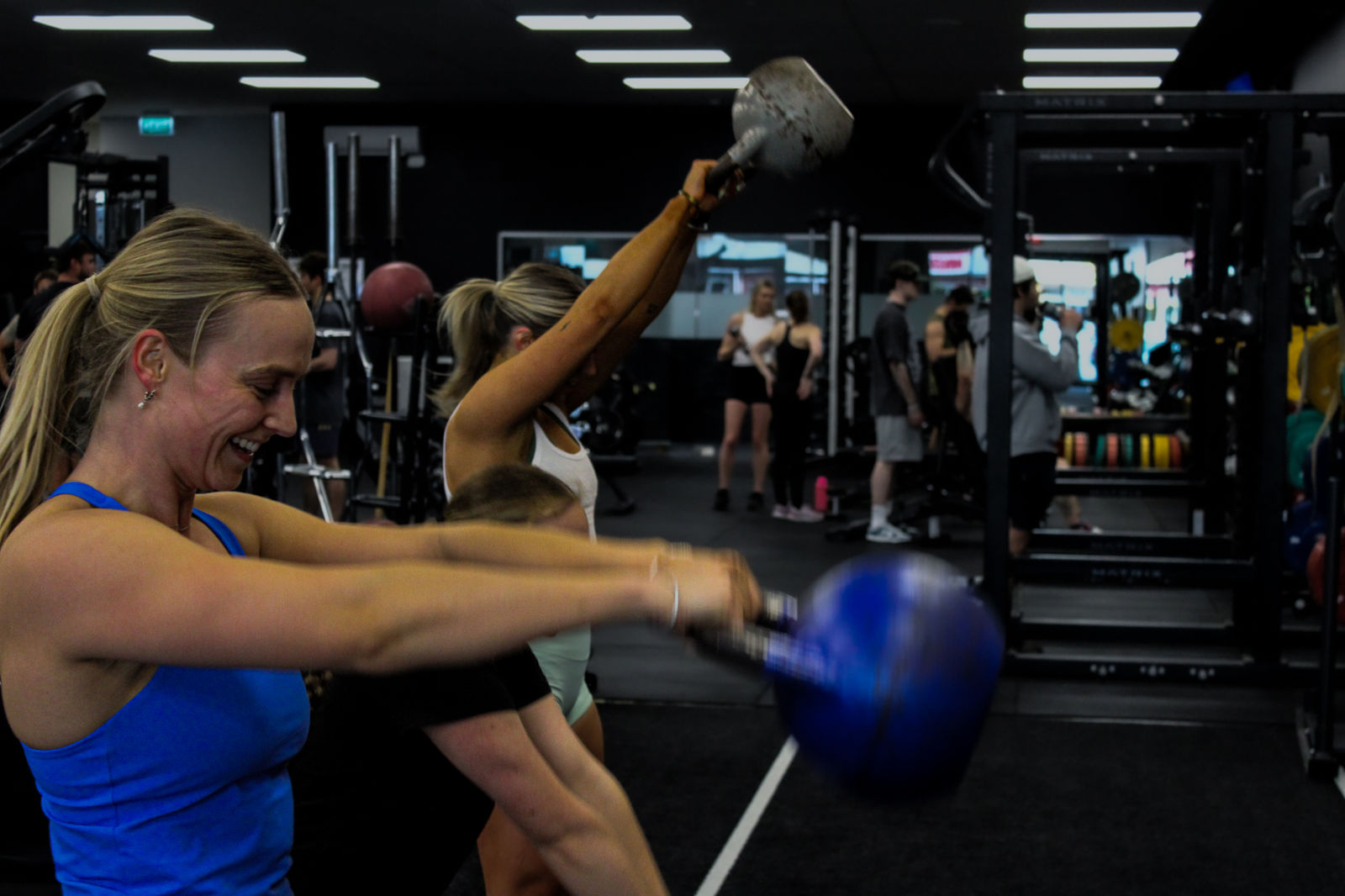 Members doing kettlebell swings in a coached class